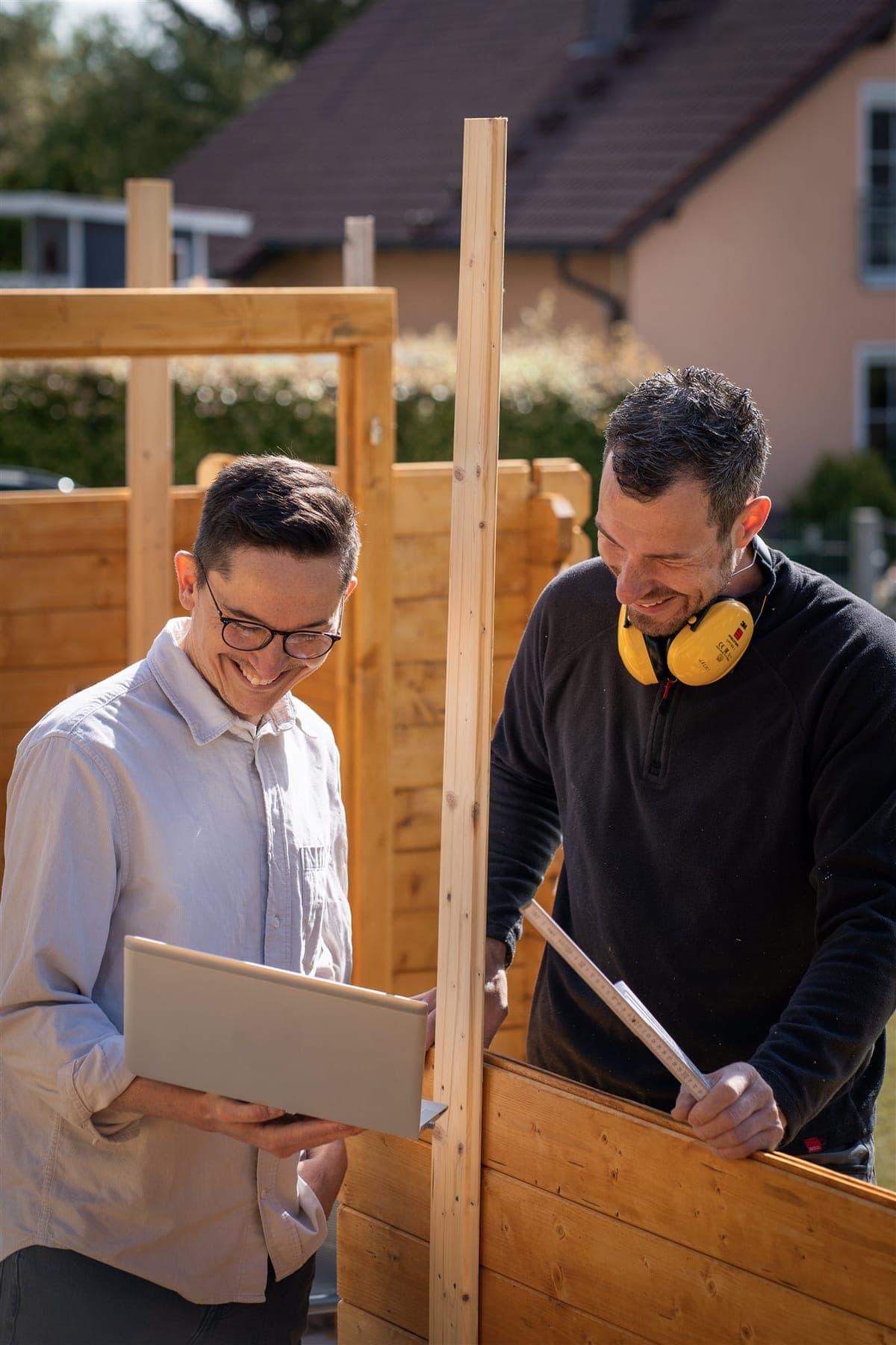 Beratung im Betrieb: Gespräch mit einem Zimmerer an der Holzwand
